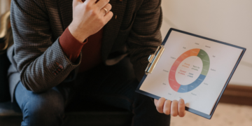 A person holding a paper with a circular chart and a pen