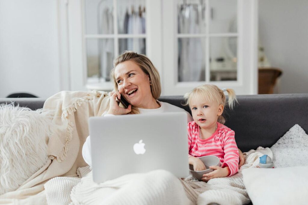 A woman talking over the phone with a child beside her