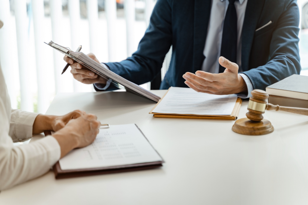 Forensic psychologist sitting at a table, talking to a person while holding documents