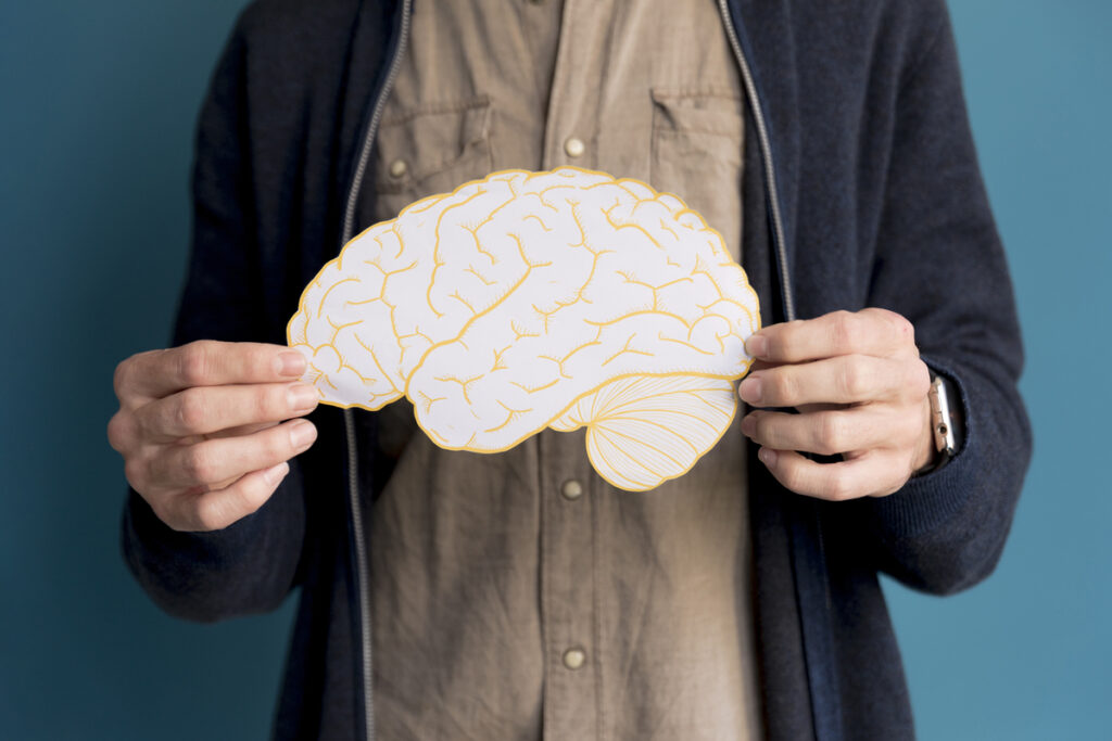 A man holding a brain made of paper