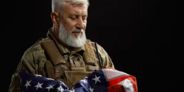 A military veteran holding the American flag to his chest