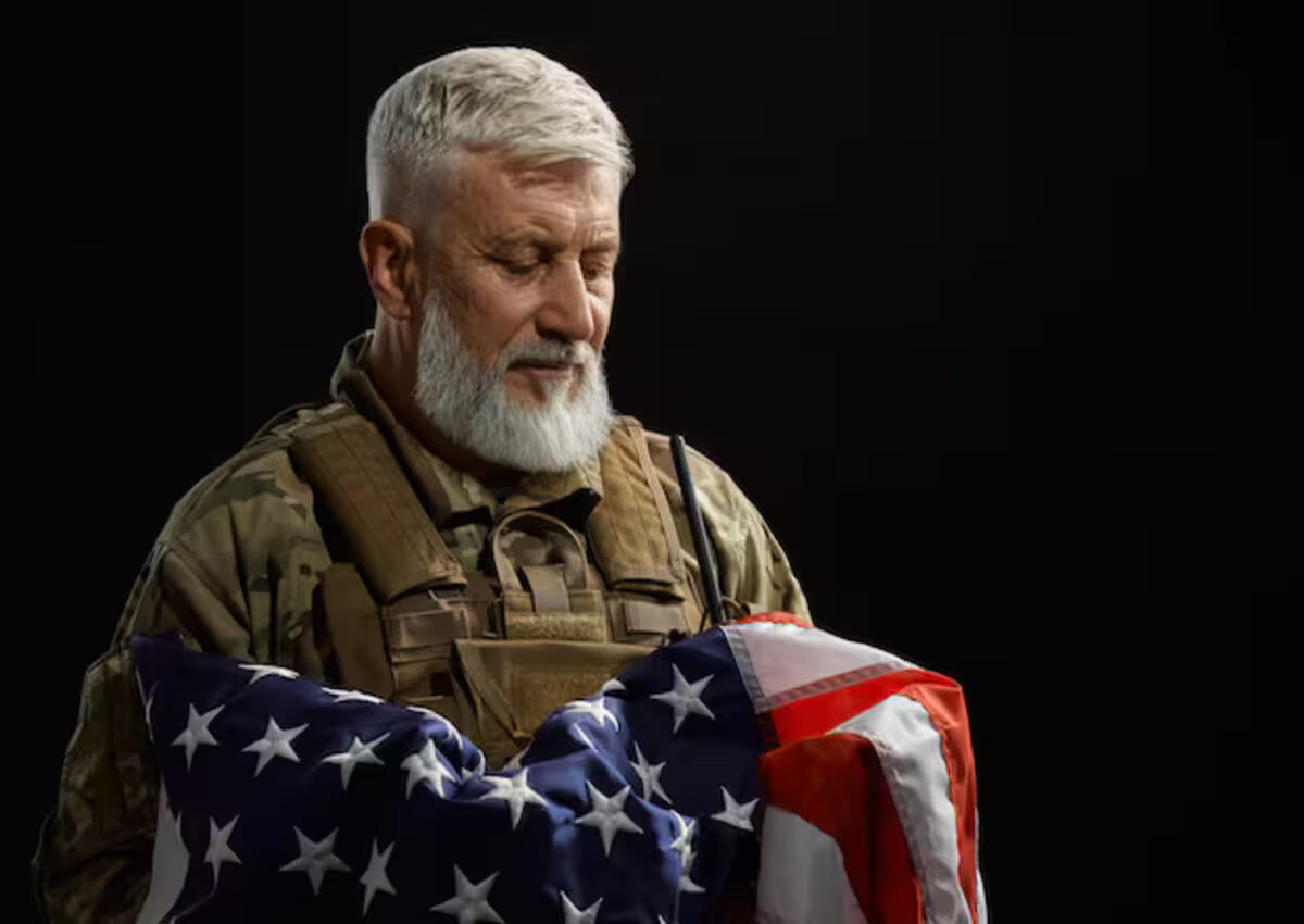 A military veteran holding the American flag to his chest