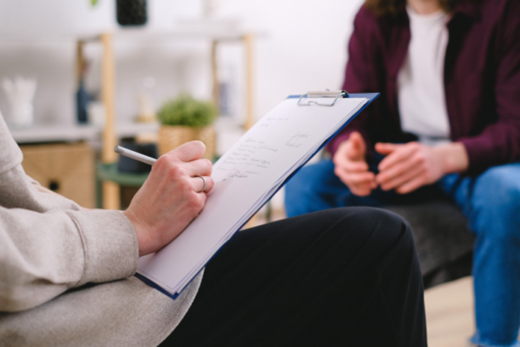 A psychologist writing her evaluation on the paper.