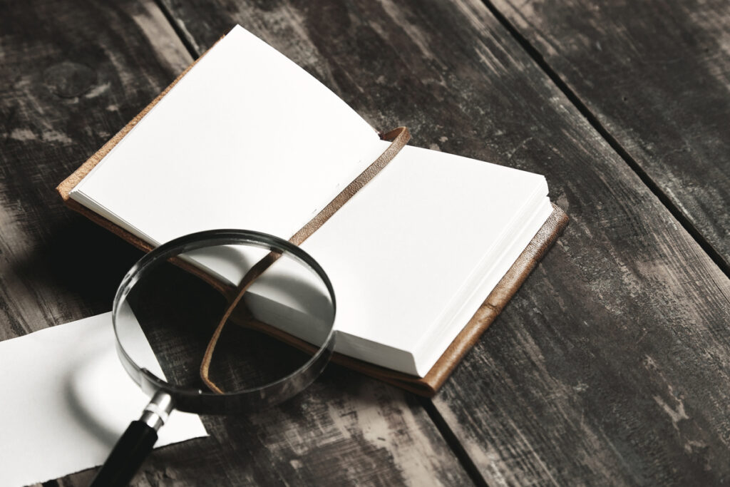 A blank book and a magnifying glass on the table.