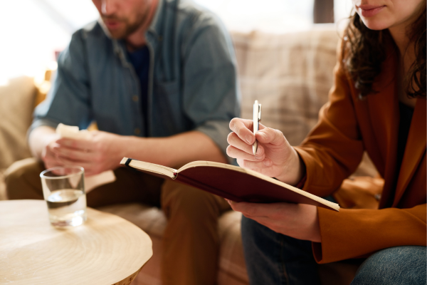 A person holding a pen and notebook
