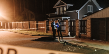 Two forensic psychologists examining evidence at a crime scene