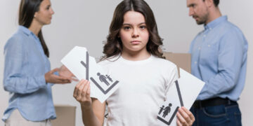 A child holding a torn image of a family.