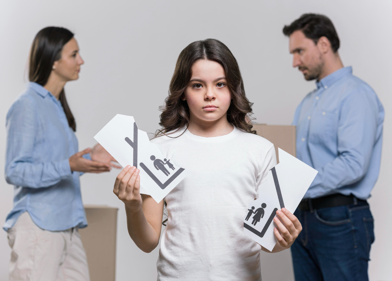 A child holding a torn image of a family.